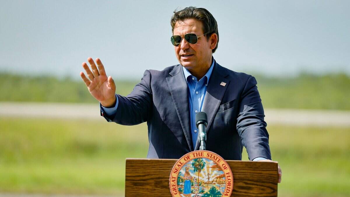 Gov. Ron DeSantis speaks to reporters during a press conference as he stands on the airplane runway of Alligator Alcatraz in Ochopee, Florida, on Friday, July 25, 2025.